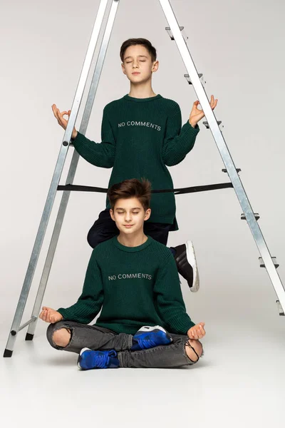 Två attraktiva killar i gröna tröjor mediterar tillsammans — Stockfoto