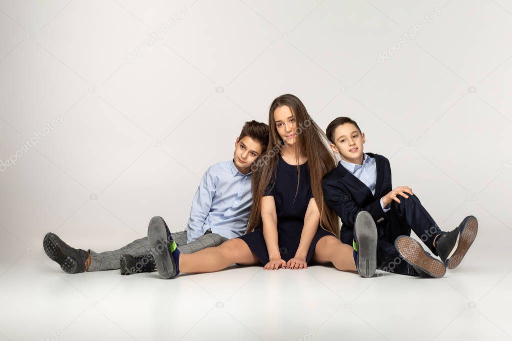 Young beautiful teenagers sitting together on the ground