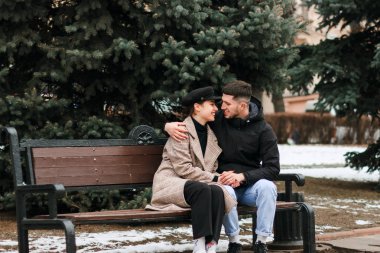 Genç çift bankta oturan ve dinlenme, birbirine bakarak