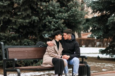 Genç çift bankta oturan ve dinlenme, birbirine bakarak