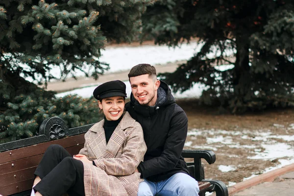 Lovely young couple sitting on the bench in the park — Stock Photo, Image