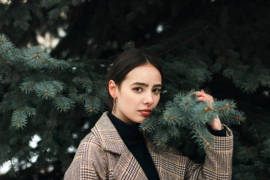 Güzel kızın ağaçları kış Park arasında ayakta