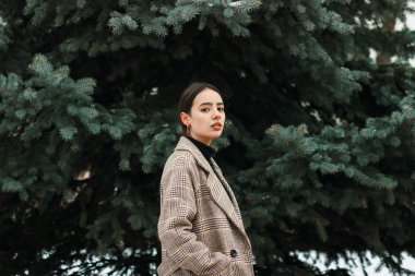 Güzel kızın ağaçları kış Park arasında ayakta