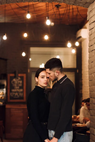 Beautiful young couple posing in cafe, standing together — Stock Photo, Image