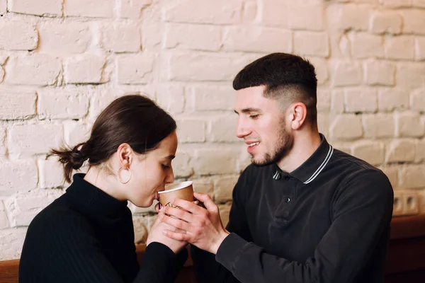 Romantic young couple drinking coffe from one cup — Stock Photo, Image