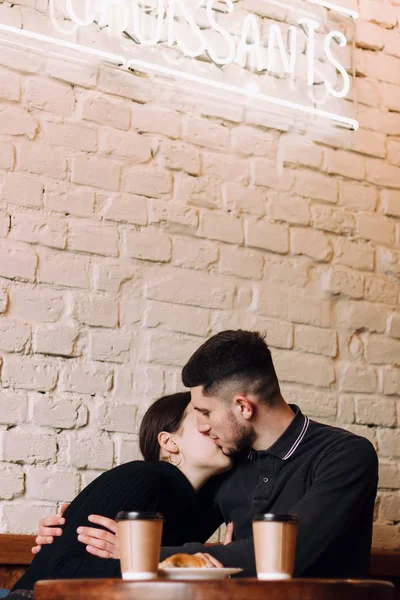 Jovem casal encantador beijando enquanto sentado no café — Fotografia de Stock