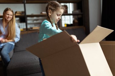 Aile yeni evinde karton kutuları açıyor