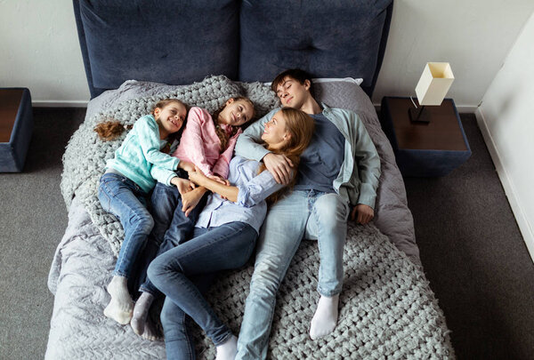 Young family on vacation in a hotel room bed