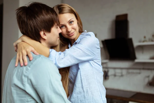 幸福的西班牙夫妇在蓝色粗斜纹棉布拥抱在厨房 — 图库照片
