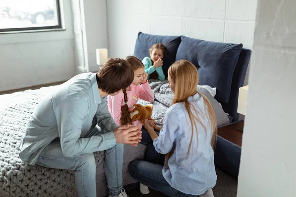 Νέοι γονείς κάθονται στην κρεβατοκάμαρα και να καθησυχάσει τους κλάμα dauther — Φωτογραφία Αρχείου