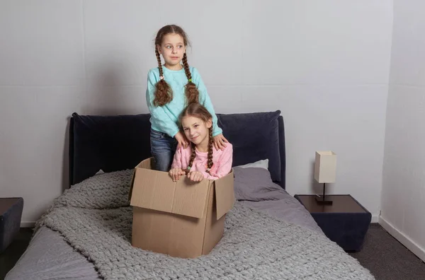 Små barn i deras nya hem att ha kul med pappkartonger — Stockfoto