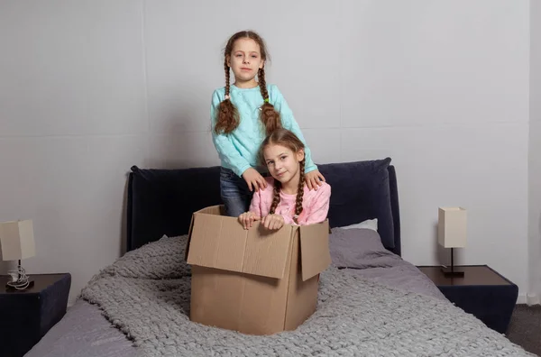 Små barn i deras nya hem att ha kul med pappkartonger — Stockfoto