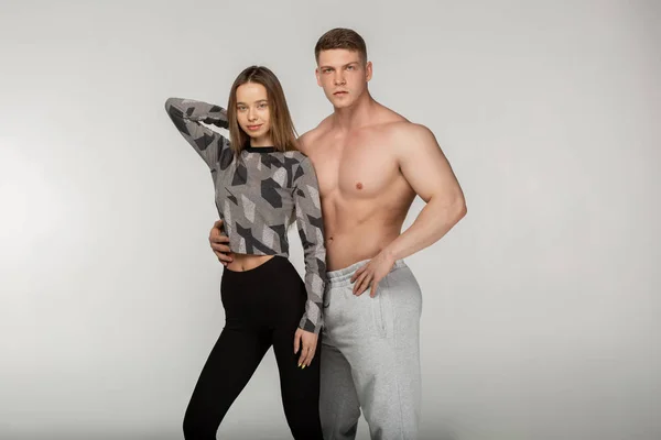 Athletic shirtless man and sporty woman in stylish sportswear — Stock Photo, Image