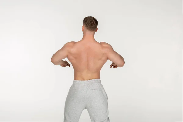 Junger muskulöser Mann zeigt seinen gepumpten Rücken — Stockfoto