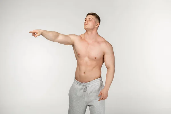 Perfil retrato de tipo musculoso sin camisa con corte de pelo corto de moda que señala a un lado con el dedo índice —  Fotos de Stock