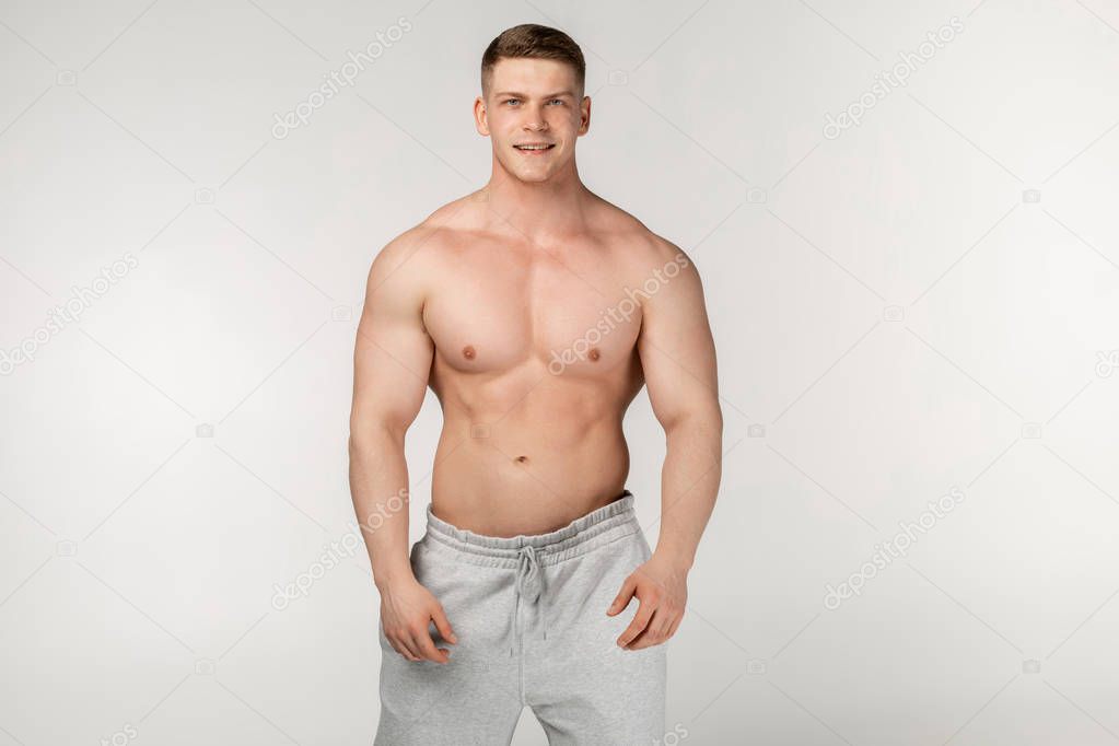 Half length portrait of young physically fit man showing his well trained body