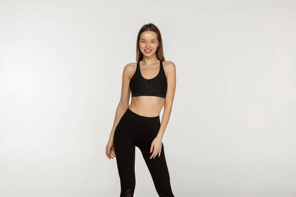 Ung smal tjej i en svart tight kostym för yoga och fitness — Stockfoto
