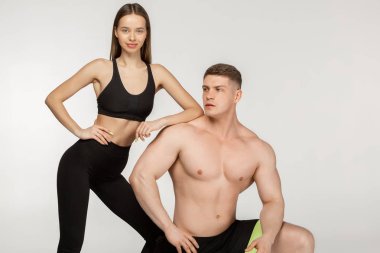 Bir diz ve güzel sportif kız çıplak gövde ayakta gömleksiz kaslı adam üstüne eğildi