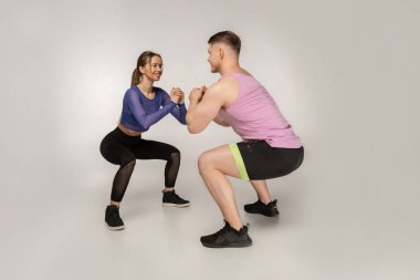 Çekici Spor hocası güzel kız nasıl sguats yapılacağını gösterir.