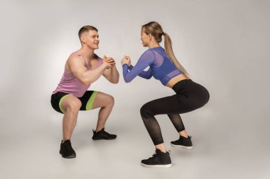 Çekici Spor hocası güzel kız nasıl sguats yapılacağını gösterir.
