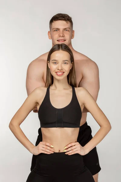 Sorrindo jovem casal saudável em fundo cinza — Fotografia de Stock