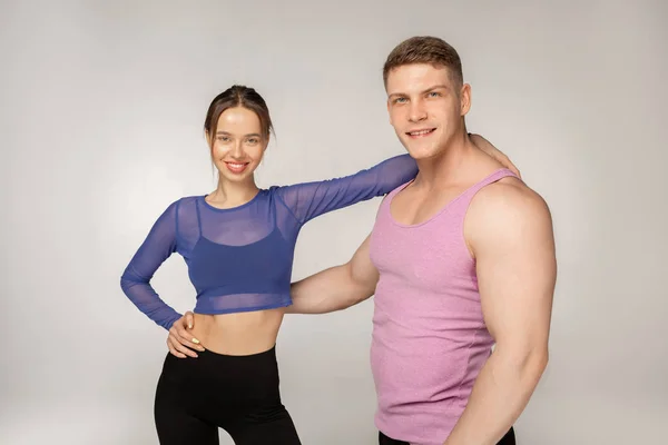 Красивая молодая улыбающаяся пара в модной спортивной одежде — стоковое фото