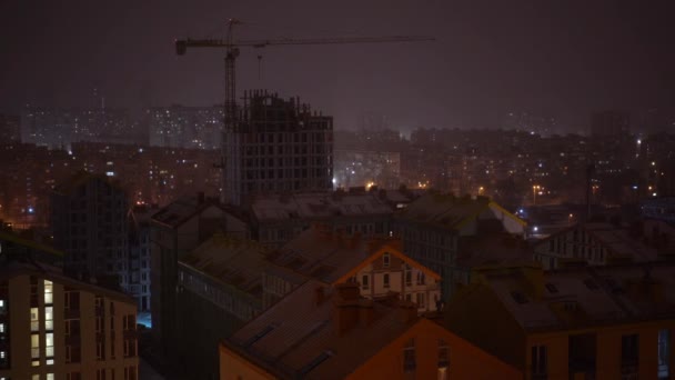 Cidade noturna durante uma queda de neve. Luzes nas janelas de edifícios altos — Vídeo de Stock