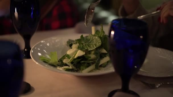 Dívka s červenými manikúra v restauraci mísí zeleninový salát s vidličkou a lžící — Stock video