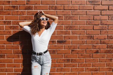 Mutlu sevimli genç hipster kadın kıvırcık saçlı güzel bir gülümseme ile