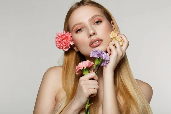 Retrato lúdico y sexy de una mujer bastante alegre con flores de primavera cerca de su cara — Foto de Stock