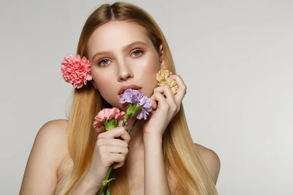 Retrato lúdico e sexy de mulher muito alegre com flores de primavera perto de seu rosto — Fotografia de Stock