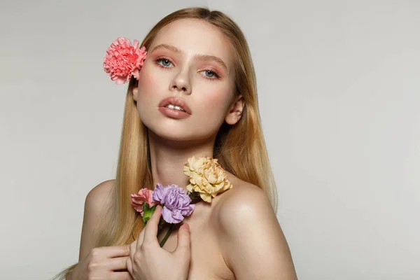 Jolie jeune fille blonde avec maquillage à la mode et fleur ping frisée dans les cheveux — Photo