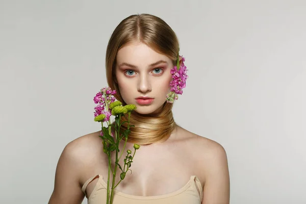 Porträtt av fräsch och vacker blond flicka med rosa blommor — Stockfoto