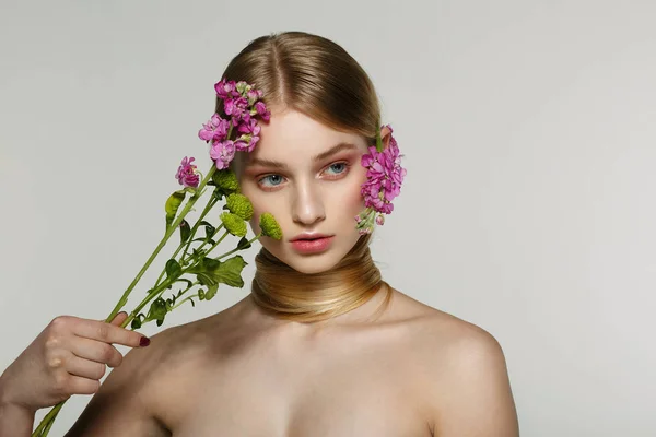 Mulher muito jovem com olhar fresco primavera, cabelo maravilhoso, maquiagem agradável, flores perto de seu rosto e no cabelo — Fotografia de Stock