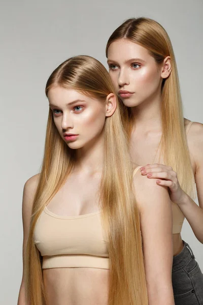 两个性感迷人的双胞胎妇女与金发长发摆姿势在魅力化妆 — 图库照片