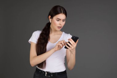 Beyaz t-shirt giyen kulak kulaklık ile ciddi yaratıcı kadın blogger