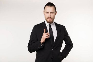 Güzel görünümlü saç modeli ile mutlu güzel sakallı adam, siyah takım elbise ve kravat giyiyor