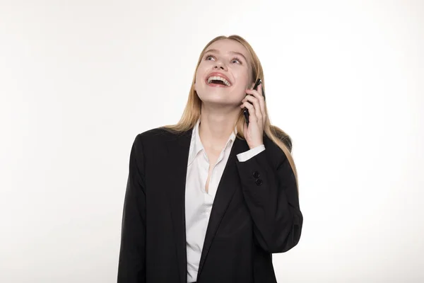 Hermosa señora rubia de negocios en traje negro está hablando en el teléfono móvil y sonriendo — Foto de Stock