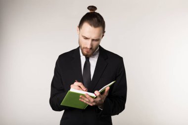 Siyah elbiseli ciddi tıraşsız işadamı çekim bel kadar dikkatle iş ortağı dinler ve bir Notebook notları alır