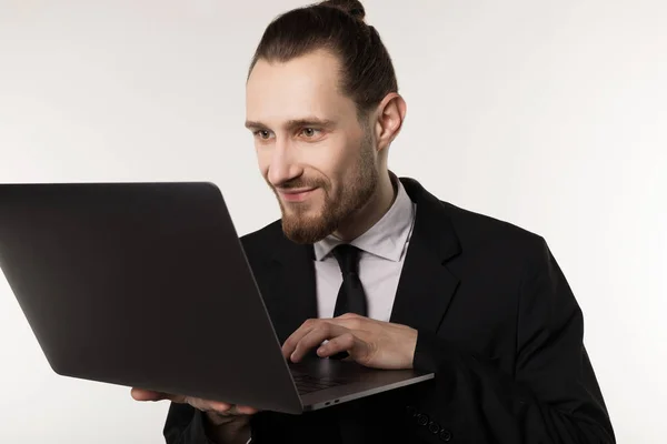 Young handsome businessman with beard and trendy hairstyle wearing black suit and tie — Stock Photo, Image