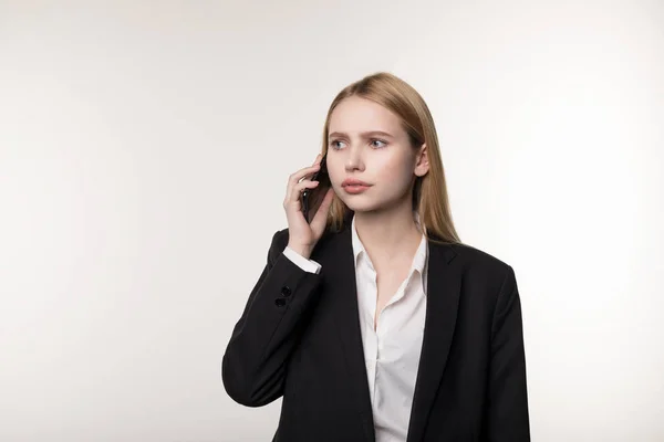 Selbstbewusste junge blonde Geschäftsfrau, die auf Mobiltelefon spricht, isoliert auf weißem Hintergrund, kommuniziert mit Geschäftspartner — Stockfoto