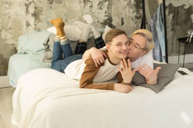 Geçenlerde yatakta gece uykusunda rahatlatıcı ve kamera bakarak evli yakışıklı Uluslararası homoseksüel çift