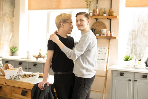 Hombre gay pareja abrazándose uno al otro en la mañana en la cocina en casa —  Fotos de Stock