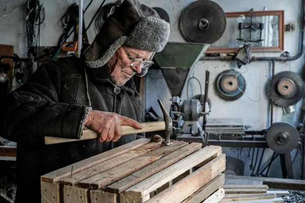 Vieux menuisier sénior en gris vêtements chauds en lunettes — Photo