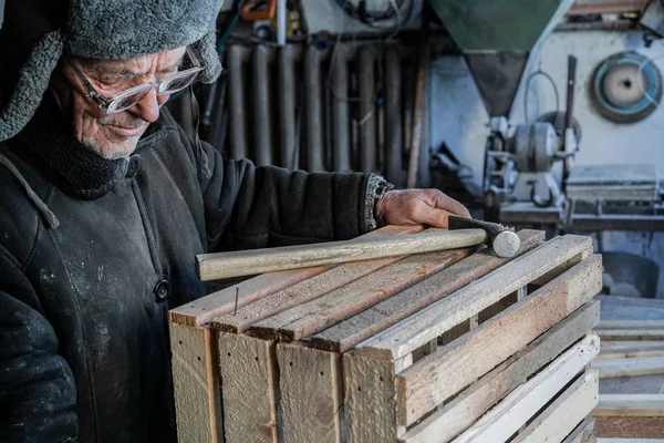 Gözlük içinde gri sıcak giysi ve şapka, eski ciddi usta