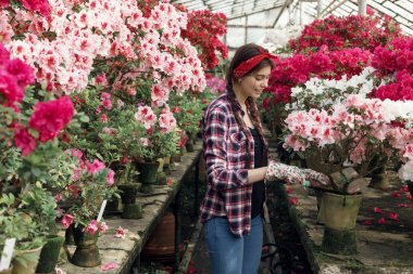 Kırmızı bir kafa bandı ile ekose gömlek güzel kız öğrenci iş eldiveni giyiyor