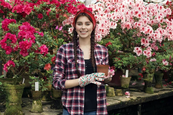 Retrato de una joven jardinero sonriente con coletas sosteniendo maceta elige qué flor trasplantar — Foto de Stock