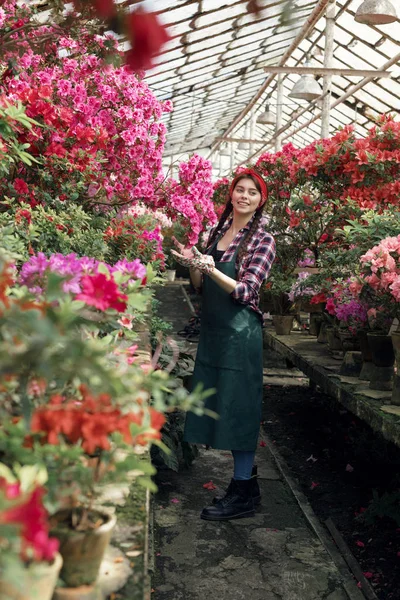 Flores de primavera y verano. Mujer feliz jardinero en ropa de trabajo mirando a la cámara — Foto de Stock