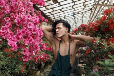 Yeşil önlük çıplak omuzlu uzun koyu saçlı çekici genç adam