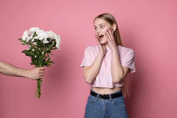 Lycklig vacker ung kvinna med blont hår överraskad av blommorna som gav hennes pojkvän — Stockfoto